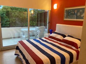 a bedroom with a bed and a balcony with a table at Punta vacaciones -piscina solo en vacaciones y fines de semana largos- in Las Gaviotas
