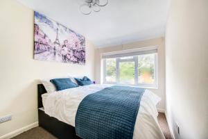 um quarto com uma cama e um quadro na parede em London serviced apartments BAFOG em Barking