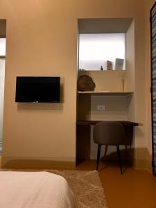 a bedroom with a desk and a television on a wall at Villa Sardino in Settimo Vittone