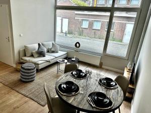 een woonkamer met een tafel en stoelen en een raam bij Creative 3 bedroom apartment 79m2 -BSH23- in Rotterdam