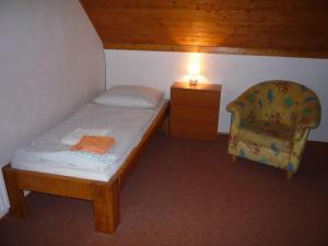 a small bedroom with a bed and a chair at Apartmány U Stoiberů in Přední Výtoň