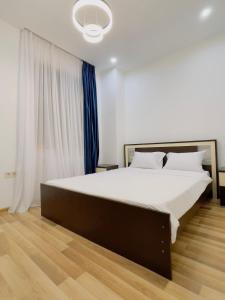 a bedroom with a large bed with white sheets at Maria House in Kutaisi