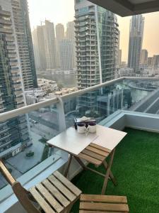 einen Tisch und Stühle auf einem Balkon mit Stadtblick in der Unterkunft Spacious 2 Bed Apt at Marina in Dubai
