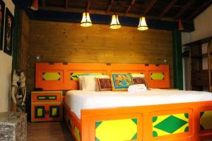 1 dormitorio con 1 cama con cabecero de madera en La Juanita Casa Hotel Ecológico, en La Estrella
