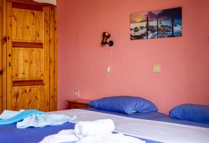 1 dormitorio con 2 camas con sábanas azules y puerta en Giola Apartments And studios 1 en Astris
