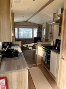 uma cozinha em plano aberto e sala de estar com um sofá em 8 Berth family caravan Selsey West Sussex em Selsey