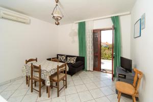 a living room with a table and a couch at Apartmani Katica in Kornić