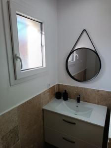 a bathroom with a sink and a mirror at Charmant studio avec piscine in Villemoustaussou