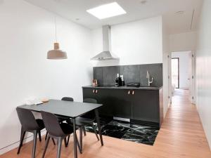 eine Küche mit einem schwarzen Tisch und schwarzen Stühlen in der Unterkunft New Ample and Cozy One Bedroom Apt in Brooklyn at Rem-Casa in Brooklyn