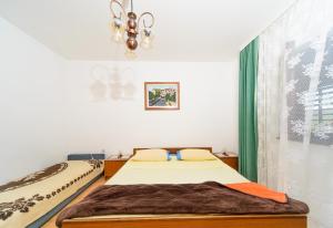a bedroom with two beds and a chandelier at Apartmani Katica in Kornić