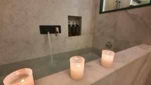 two candles sitting on a counter in a bathroom at Retiro Studio in Madrid