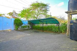 a blue building with a green canopy next to a fence at Shali Hotel in Wote