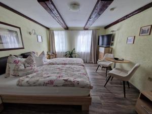 une chambre d'hôtel avec un lit, une table et des chaises dans l'établissement Pension Zum Lukullus, à Wernigerode