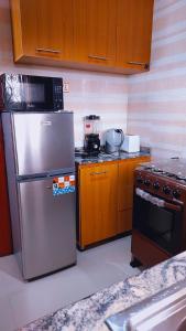 a kitchen with a stainless steel refrigerator and a stove at Cogent Apartments and Hotel in Uyo