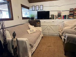 a bedroom with a bed and a flat screen tv at Pueblo Arriba Hostel in Punta Del Diablo