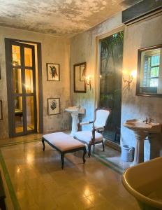 een badkamer met een wastafel, een stoel en een tafel bij Coqui Coqui Meson de Malleville - Valladolid in Valladolid