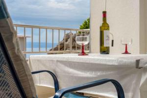a table with a bottle of wine and two glasses at Baska Voda Apartment 7 in Baška Voda