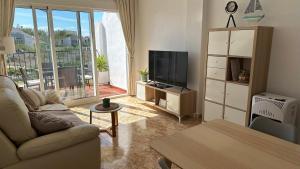 een woonkamer met een bank en een flatscreen-tv bij Casa La Marie POOL KLIMA TV FREE WIFI GARAGE in Orihuela