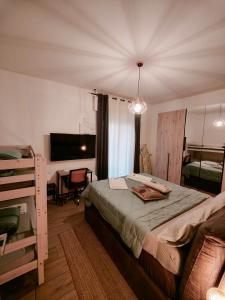 Dormitorio con cama, escritorio y TV en MC FLY ROOMS Malpensa airport, en Gallarate