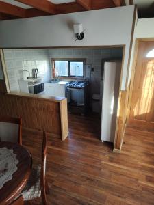 a kitchen and dining room with a table and a counter at Cabañas Vera in Punta Arenas