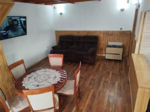 una sala de estar con una mesa y un sofá en Cabañas Vera, en Punta Arenas