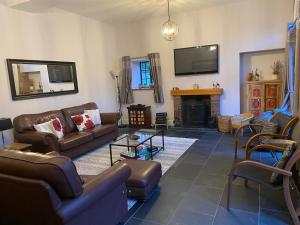 uma sala de estar com sofás e uma lareira em The Stables em Frizington