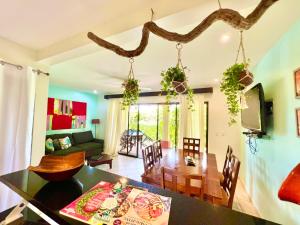 een eetkamer en een woonkamer met een eettafel bij Tropical Gardens Suites and Apartments in Coco