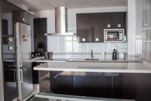 uma cozinha com um lavatório e um frigorífico em Apartamento junto al mar en Torrox Costa em Málaga