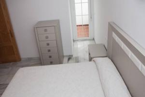 um quarto com uma cama, uma cómoda e uma janela em Apartamento junto al mar en Torrox Costa em Málaga