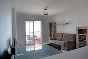 uma sala de estar com um sofá e uma mesa em Apartamento junto al mar en Torrox Costa em Málaga