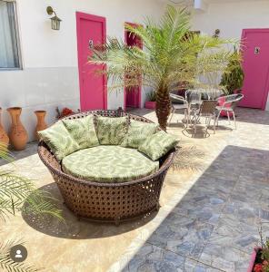 ピラーニャスにあるPousada Bonita , Piranhas ALのピンクのドアが備わる客室で、籐の椅子と枕が備わります。