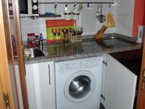 a kitchen with a washing machine and a sink at Covelo in Porto