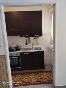 a kitchen with black cabinets and a sink at Appartamento centro Brusson. in Brusson +4 photos