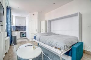 Dormitorio blanco con cama y mesa en Magnifique studio rénové gare 2per wifi, en Joinville-le-Pont