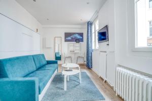 a living room with a blue couch and a table at Magnifique studio rénové gare 2per wifi in Joinville-le-Pont