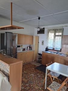 a kitchen with wooden cabinets and a table in it at Μονοκατοικία Μονοπήγαδο in Monopígadhon