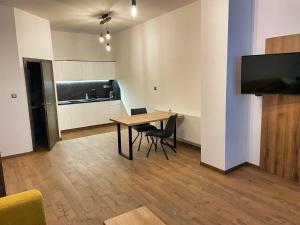 a dining room with a table and chairs and a television at Apartment Elinel in Žilina