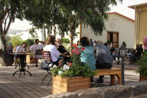 un grupo de personas sentadas en un banco del parque en Assaf Boutique Winery & Cabins en Kidmat Tsvi