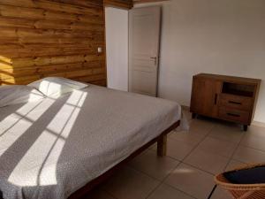 ein Schlafzimmer mit einem Bett und einer Holzwand in der Unterkunft VILLA MARIE in Marigot