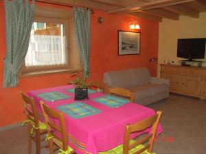 a dining room with a pink table and a couch at Casa Martina in Livigno