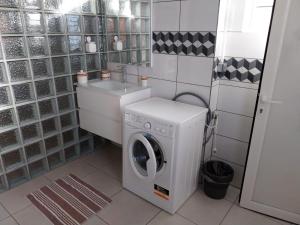 eine Waschküche mit einer Waschmaschine und einem Waschbecken in der Unterkunft VILLA MARIE in Marigot
