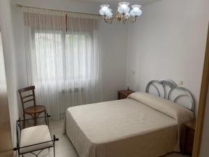 um quarto com uma cama, uma cadeira e uma janela em El enebrón - Hoces del río Duratón 