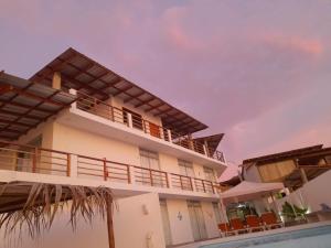 un edificio con balcón junto a una piscina en Las Fragatas Casa Hotel, en Canoas de Punta Sal