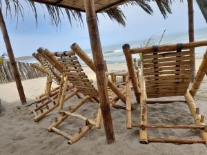 un grupo de sillas sentadas en la playa en Las Fragatas Casa Hotel en Canoas de Punta Sal