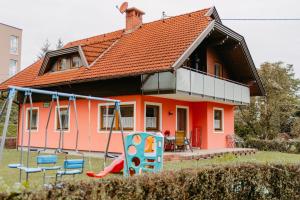 ein Haus mit einem Spielplatz davor in der Unterkunft Ferienhäuser Inge und Seeblick in Oberaichwald