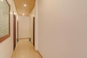 戈勒克布爾的住宿－OYO Flagship R V Palce，走廊上设有白色的墙壁和墙上的绘画作品