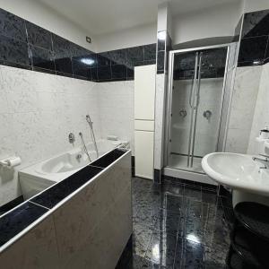 La salle de bains est pourvue d'une baignoire, d'un lavabo et d'une douche. dans l'établissement Alloggio in Centro Città con Parcheggio Privato e WIFI, à Potenza