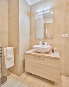 uma casa de banho com um lavatório e um espelho em Monviso Mono - Exclusive Apartment em Milão