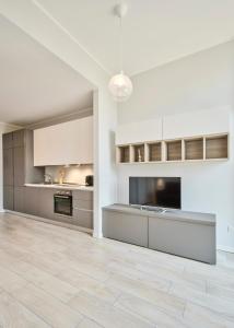 una cocina vacía con armarios blancos y suelo de baldosa en Monviso Mono - Exclusive Apartment, en Milán