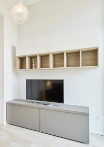 uma sala de estar com televisão e uma parede branca em Monviso Mono - Exclusive Apartment em Milão